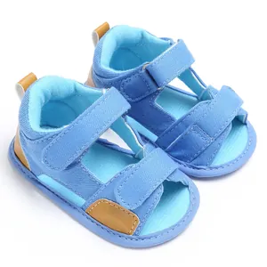 Detailed macro view of blue denim baby sandals with adjustable velcro straps.