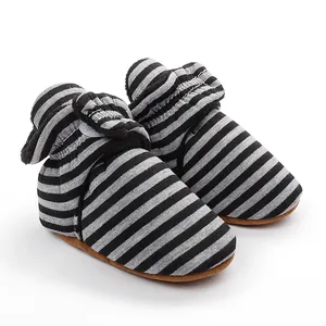 Gros plan de bottines d'hiver rayées gris et noir pour bébé avec semelles souples et polaire