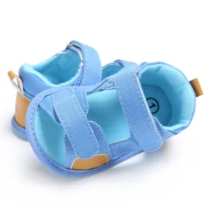 Detail view of blue denim baby sandals featuring velcro straps and a soft comfortable sole