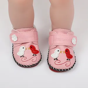 Vista detallada de zapatos de bebé rosa con bordado de pájaros y suela antideslizante