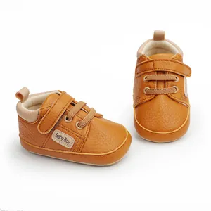 Detail view of brown leather baby walking shoes for infants with Baby Boy patch design
