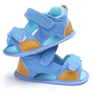 Detailed view of blue denim baby sandals with adjustable velcro straps and brown accents
