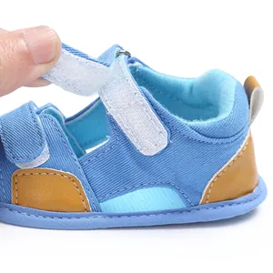 Close-up detail of the adjustable velcro strap on denim baby sandals for toddlers.