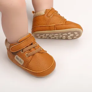 Detailed view of brown faux leather baby walking shoes featuring soft soles and hook-loop strap