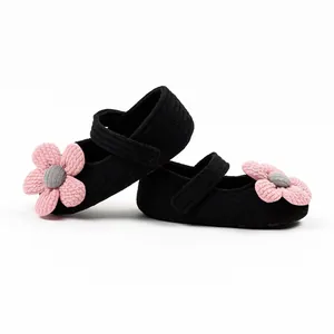 Detailed view of baby girl knitted princess walking shoes with pink flower decoration