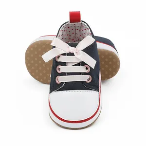 Detail shot of navy blue baby girl walking shoes with elegant pink ribbon bow laces