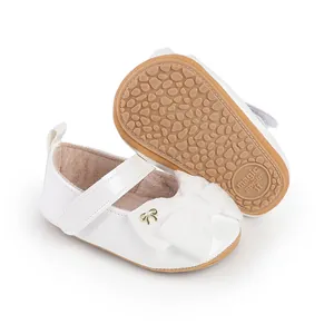 Detalle de zapatos de princesa para bebé blanca con lazo y suela antideslizante suave