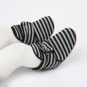Détail rapproché des bottes d'hiver rayées pour bébé avec doublure polaire et velcro