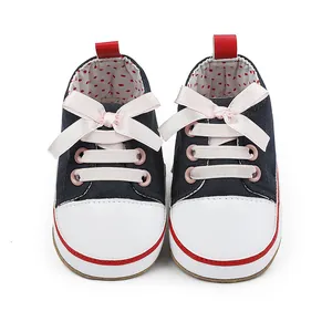 Detail shot of navy blue baby girl pre-walker shoes with pink satin bows and white toe caps