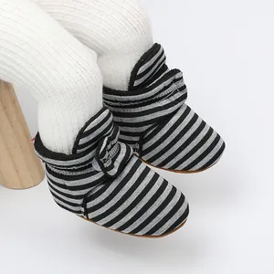 Gros plan sur les bottines d'hiver rayées pour bébé avec doublure en polaire chaude