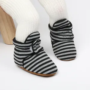 Gros plan de bottines de marche hivernales pour bébé avec des rayures grises et noires