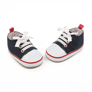 Detailed view of navy baby walking shoes with pink ribbon laces and polka dot lining