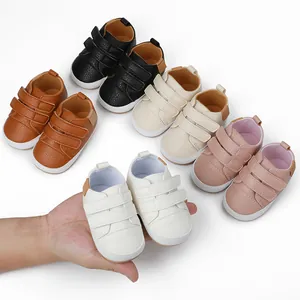 Set of colorful soft sole baby sneakers for 0-1 year olds showing size on hand