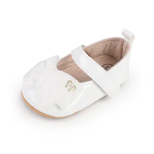 Primer plano de zapato de princesa de charol blanco para bebé con lazo suave