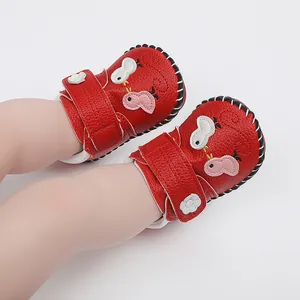 Primer plano de zapatos rojos de bebé con diseño de pollito y suela cosida a mano