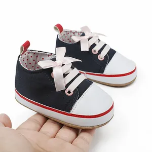 Close-up detail of navy blue baby girl walking shoes featuring a soft pink ribbon bow