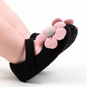 Close-up of black knit baby girl walker shoe with detailed pink flower decoration