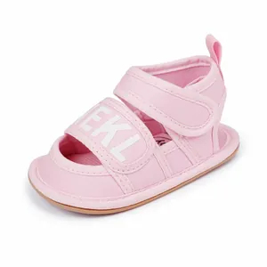 Detailed macro view of pink canvas baby sandal with white EKL lettering