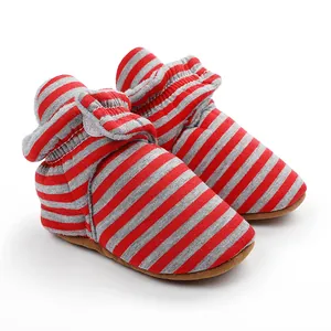 Détail de chaussons d'hiver pour bébé à rayures rouges et grises avec semelles souples