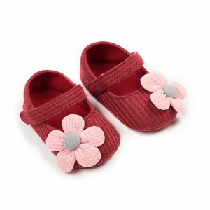 Close-up detail of wine red knitted baby girl princess walker shoes with pink flowers