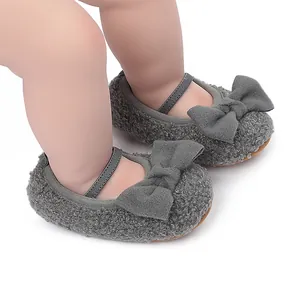 Detalle de zapatos de bebé grises de felpa con lazos suaves en el pie de un modelo de muñeca