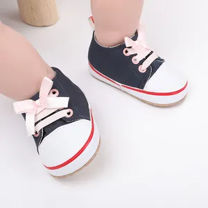 Detailed view of navy baby girl walking shoes with cute pink ribbon bow and white toe