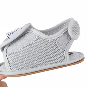 Nahaufnahme von atmungsaktivem grauem Mesh-Gewebe und Klettverschluss am Babyschuh