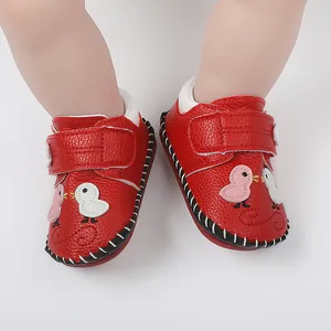 Vista detallada de zapatos rojos de bebé con suelas de goma cosidas a mano y velcro