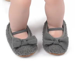 Detalle de zapatos de bebé grises de felpa con lazo y banda elástica muy cómoda