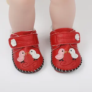 Detalle de zapatos primeros pasos en cuero rojo con lindo bordado de pájaro para bebés