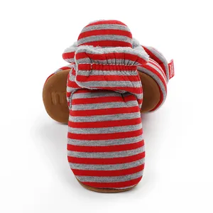 Détail des chaussons pour bébé à rayures rouges et grises avec semelles souples