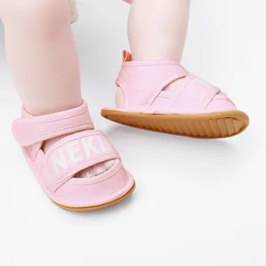 Close-up view of pink baby walking sandals featuring NEKL print and durable non-slip rubber soles