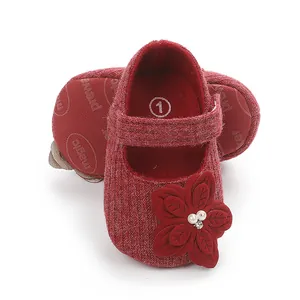 Dettaglio scarpine neonato Mary Jane in maglia rossa con decorazione fiore e perle