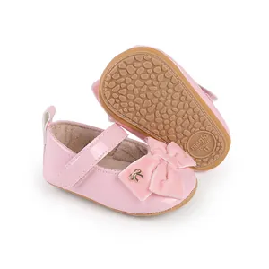 Detalle de zapatos rosa de princesa para bebé con lazo de terciopelo y suela antideslizante