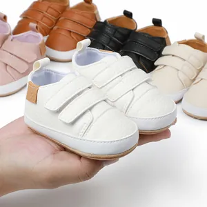 Close-up of white faux leather baby walker shoes with double hook-and-loop straps