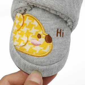 Nahaufnahme einer Welpenstickerei auf grauen, fleecegefütterten Baby-Winterschuhen