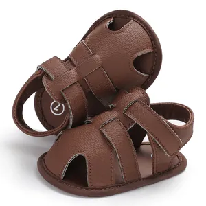 Gros plan de sandales marron pour bébé en cuir PU avec semelles souples et bout rond.