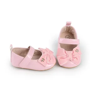 Detalle de zapatos de princesa rosas para bebé con lazo de terciopelo y correa de velcro