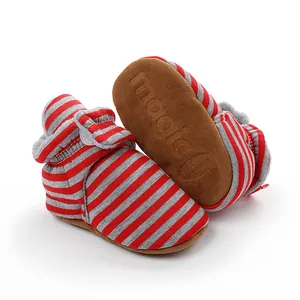 Vue détaillée de chaussons de bébé en polaire rayés rouges et gris à semelles souples