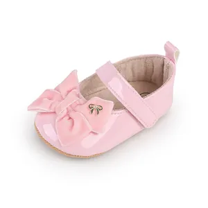 Primer plano de un zapato de princesa rosa para bebé con lazo de terciopelo.