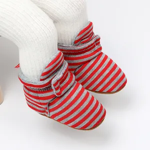 Vue détaillée des bottes d'hiver rayées rouge et gris pour bébé avec doublure polaire