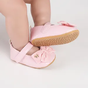 Primer plano de zapatos de princesa para bebé en charol rosa con lazo de terciopelo.