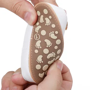 Flexible anti-slip sole of white baby walker shoes shown being bent by hands