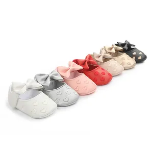 Detail niedlicher Babyschuhe mit Herzmuster und Schleife in verschiedenen Farben