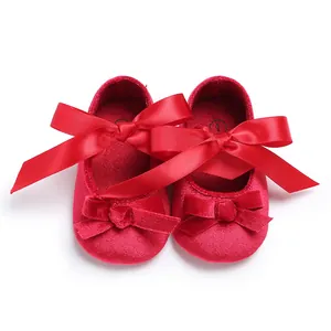 Vue détaillée des chaussures de marche rouges en velours pour bébé avec un grand nœud.