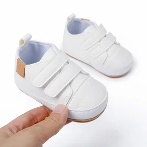 Detailed close-up of white faux leather baby walker shoes with stylish brown heel accents