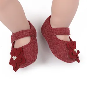 Dettaglio della scarpa da principessa rossa per neonati con fiore e perla decorativi