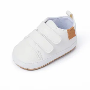 Detailed view of white faux leather baby walker shoes featuring double velcro straps