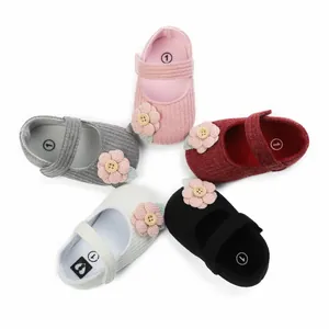 Nahaufnahme von weichen Strick-Babyschuhen in verschiedenen Farben mit Blumendetails