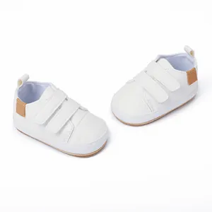 Detailed view of white baby walking shoes with double velcro straps for 0-1 year old infants